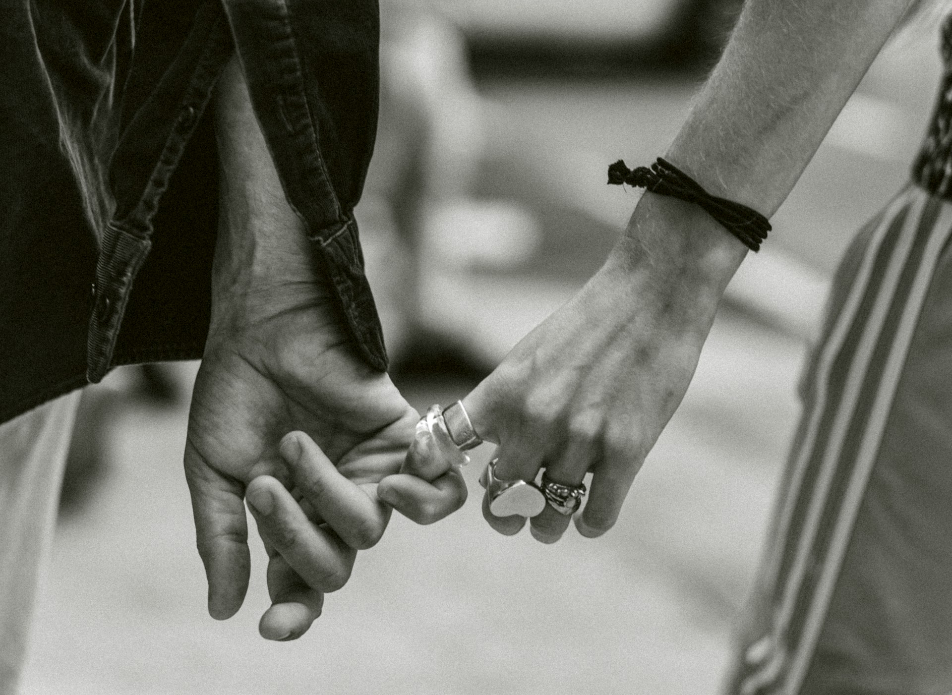 grayscale photography of couple holding hands while walking